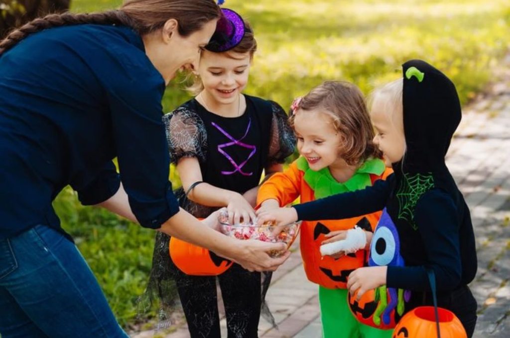 Niños tomando dulces de un bowl: significado de pedir calaverita