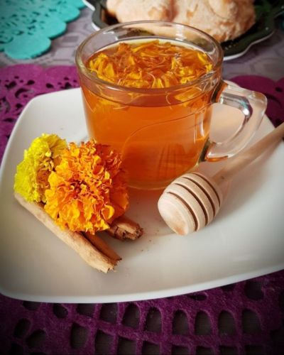 Té de flor de cempasúchil con flores y papel picado como decoración