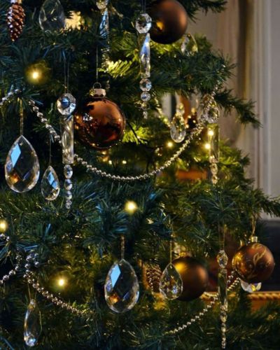 Adornos brillabtes sobre árbol verde y esferas café 