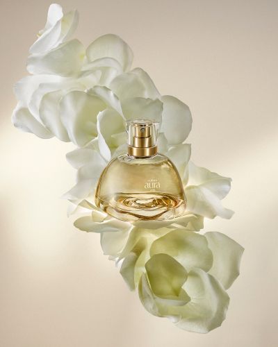 Botella del nuevo perfume de Natura con rosas de fondo