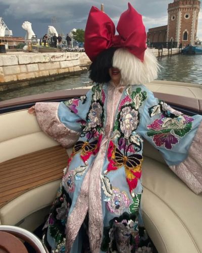 Sia con su look caracteristico sobre un bote