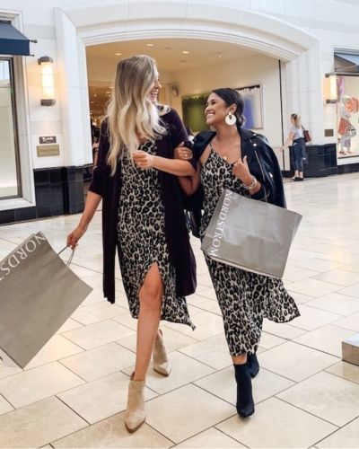 Dos mujeres caminando en el centro comercial, comprando juntas