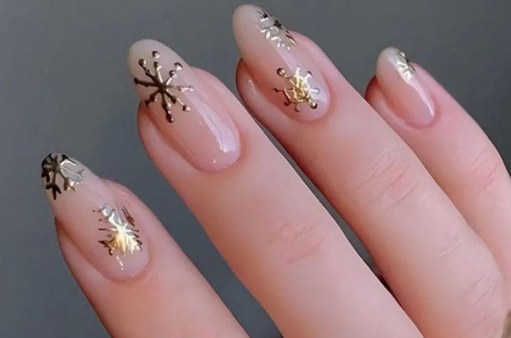 Manicure nude con snowflakes dorados