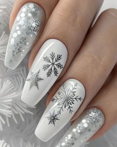 Diseños de uñas con copos de nieve en stickers sobre base blanca