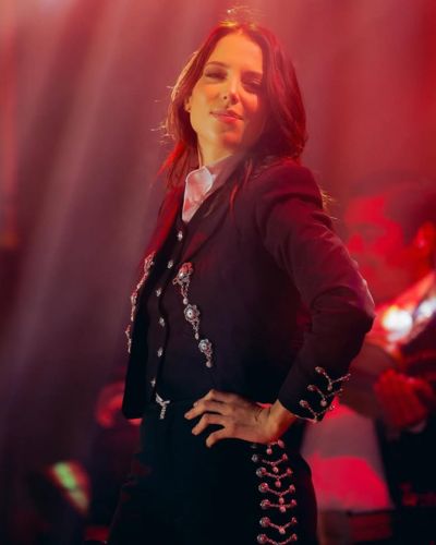 Majo sobre el escenario portando un traje de mariachi