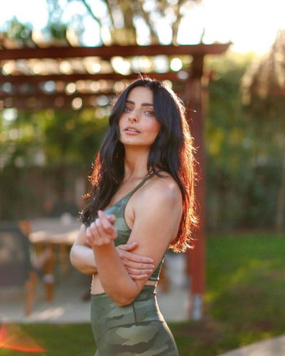 Aislinn Derbez posando en vestido verde bajo el atardecer