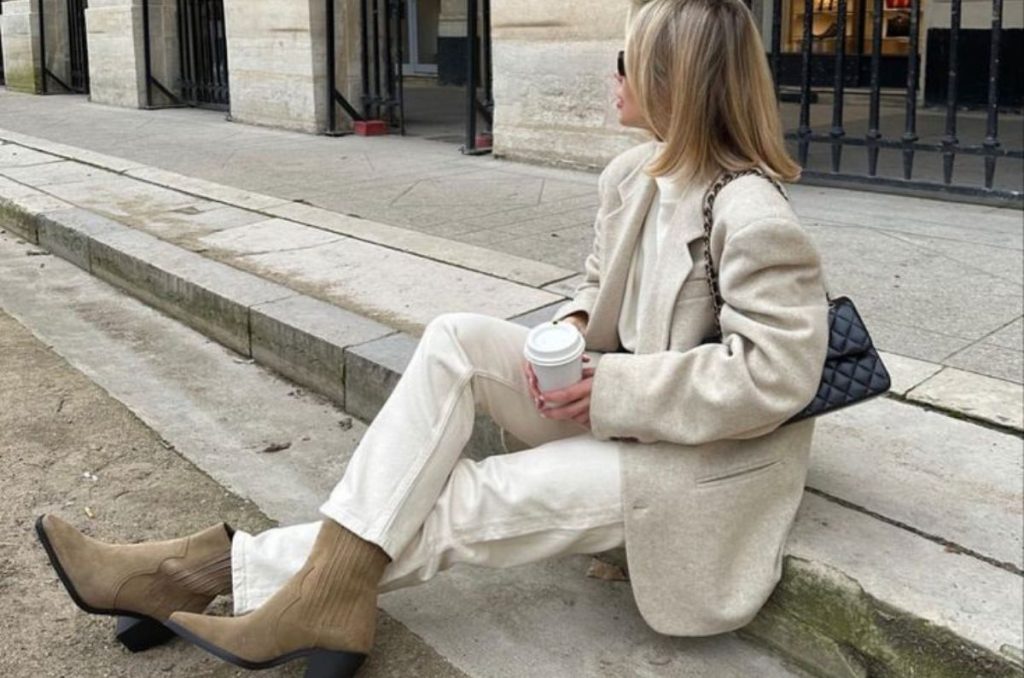 Look con prendas neutras y botas beige