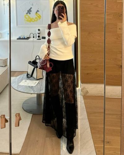 Outfits para el concierto de Bad Bunny con falda de encaje, sueter hueso y botas altas negras