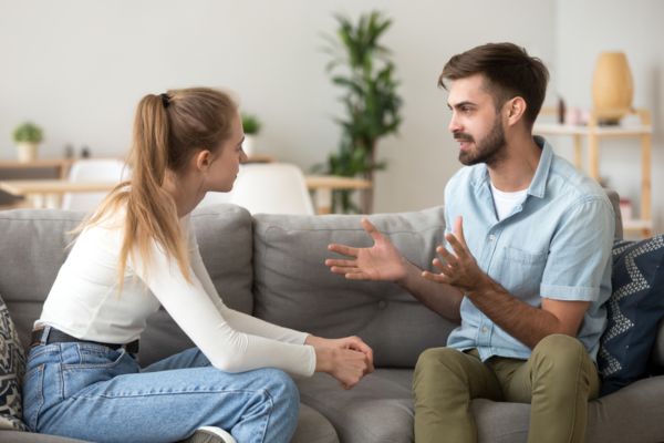 Pareja conversando seriamente en un sofá, mostrando tensión y posibles señales de que el matrimonio no va a durar