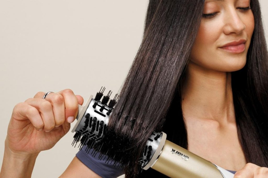 Mujer se alisa el cabello con la Shark Glam