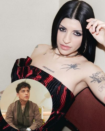 Foto de Cazzu usando un corset negro con detalles en rojo y en la parte inferior una foto de Christian Nodal