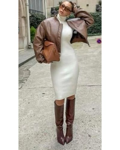 Outfit de Navidad con vestido blanco, botas altas café y bomber jacket
