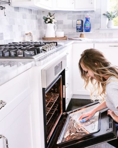 Mujer haciendo limpieza en su horno