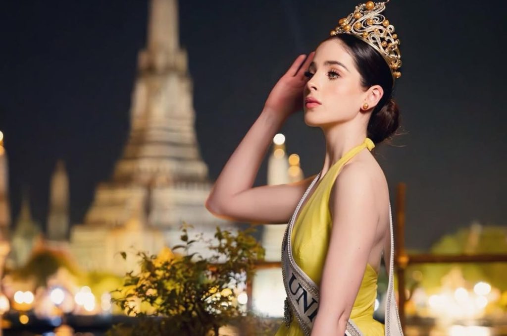 Foto de Fátima Bosch posando con su corona de Miss Universe en un vesitdo amarillo