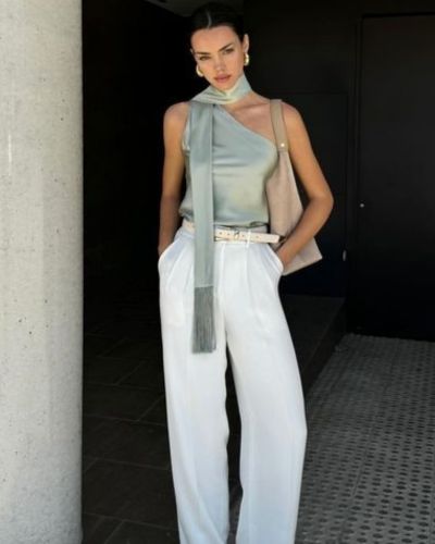 Outfit con blusa satinada asimétrica y pantalón sastrero blanco