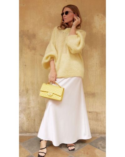 Outfits amarillos para Año Nuevo: falda satinada blanca + suéter tejido XXL
