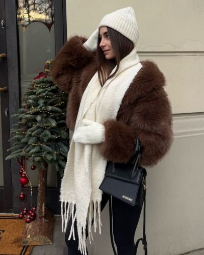 Looks de invierno con abrigo de peluche, jeans negros, bufanda, gorro y guantes beige