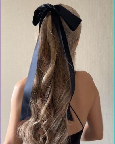 Medio recogido con listón negro como accesorio 