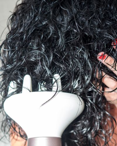 Mujer seca su cabello con un difusor