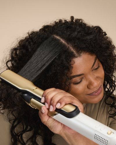 Mujer con cabello rizado se alisa el pelo con la nueva Shark Glam