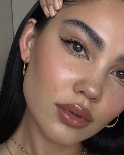 Foto de maquillaje natural con cat eye sutil en color negro y labios nude con gloss