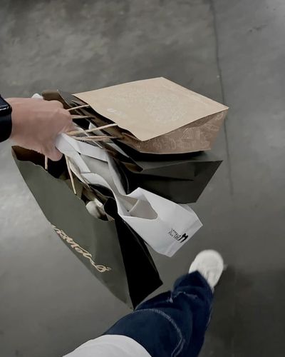 Cómo identificar ofertas reales: foto en plano cenital de una persona sosteniendo bolsas de tiendas