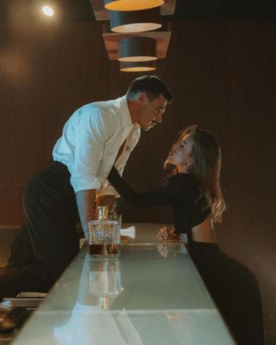 Pareja coqueta en un bar mostrando química y atracción mutua