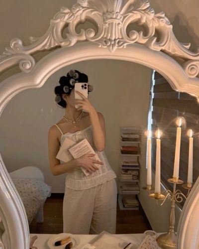 Foto de mujer frente al espejo con tubos en la cabeza 