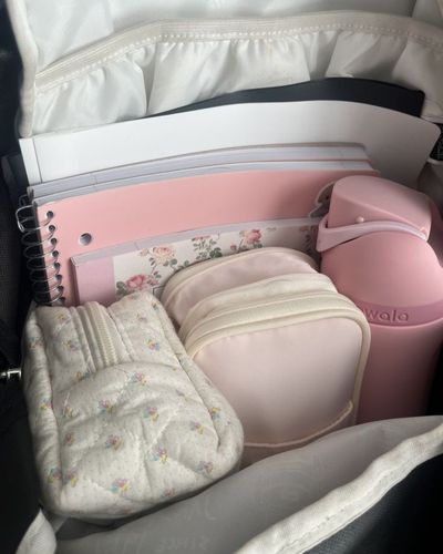 Foto de mochila con cuadernos, termo y kit de emergencia para niñas