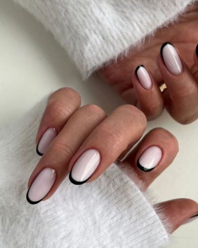 Manos de tez morena con uñas efecto milky y micro french color negro