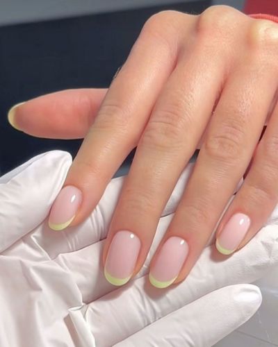 Manos de tez clara con uñas francesas verde lima