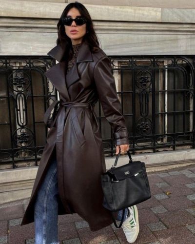 Foto de mujer usando un look casual chic, con pantalón de mezclilla, prenda de piel y tenis deportivos