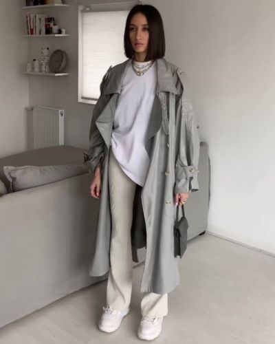 Look de gym extra glam con abrigo de cuero, pants gris y playera XXL en color blanco