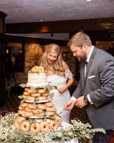 Foto de novios el día de su matrimonio comiendo donas 