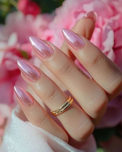 Foto de mano con forma de uña almendra con un diseño chrome en color rosa