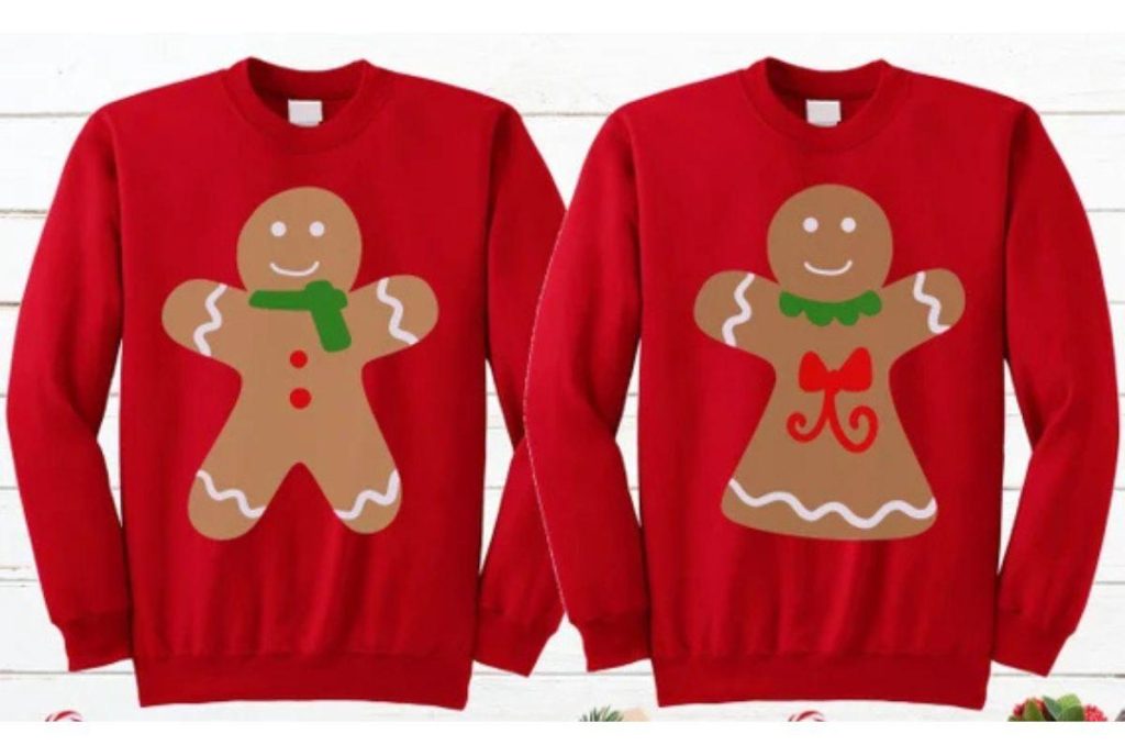 Pareja usando ugly sweaters de galleta de jengibre y glaseado, disfrutando juntos de la temporada navideña