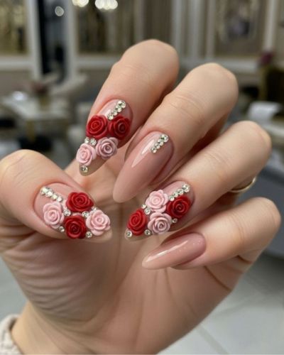 Foto de manicura con flores en 3D de color rojo y rosa