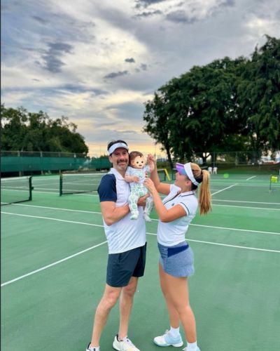 Eduardo Videgaray y Sofía Rivera Torres posan con su bebé en una cancha de tenis durante una actividad familiar.