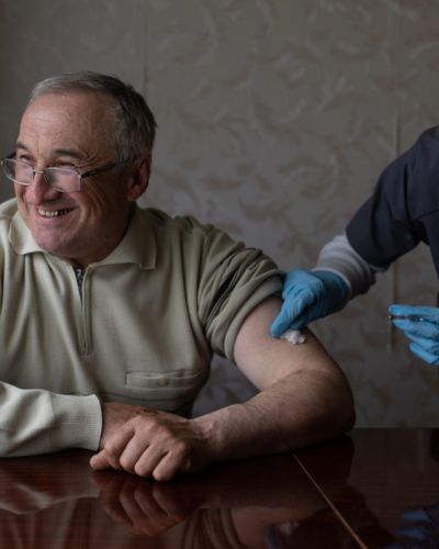 Adulto mayor recibiendo vacuna en el brazo como medida de prevención contra el sarampión en México.
