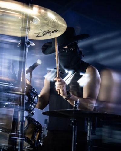 Baterista en vivo durante presentación en Tecate Emblema 2026 con iluminación dramática y escenario profesional.