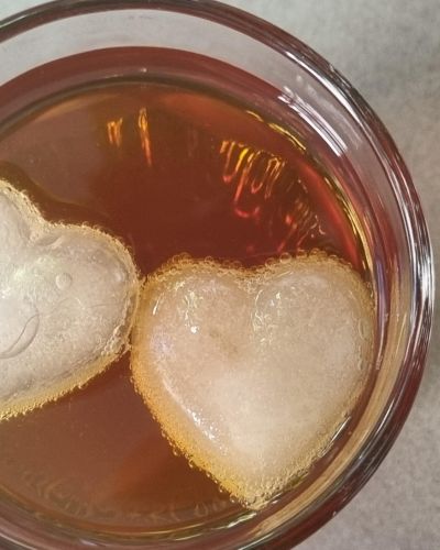 Vaso con kombucha y cubos de hielo en forma de corazón.