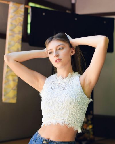 Top blanco de encaje sin mangas con jeans, look femenino y fresco en tendencia 2026.