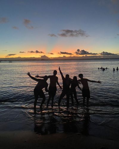 Grupo de amigos en la playa al atardecer durante vacaciones de Semana Santa.