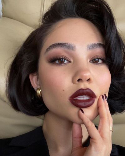 Maquillaje soft power con labios vino intenso, piel pulida y cejas definidas que proyectan autoridad.