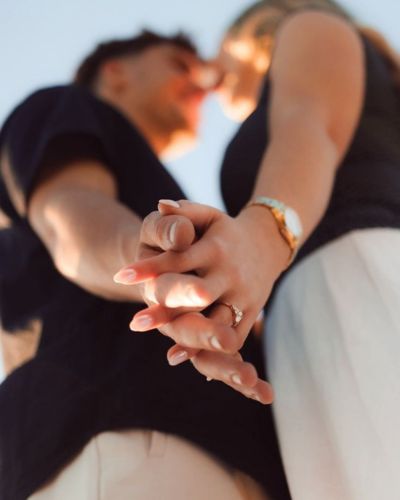 Foto de pareja en plano nadir donde se muestran sus manos entrelazadas