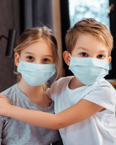 Niños con cubrebocas en escuela para prevenir contagios de sarampión.