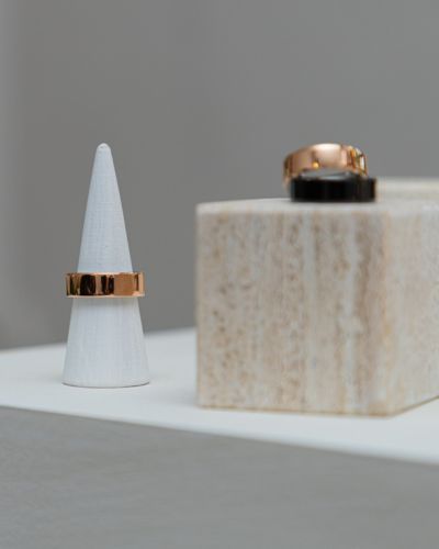 Detalle del OURA Ring 4 Ceramic en exhibición: anillo inteligente en soporte blanco con acabado premium.