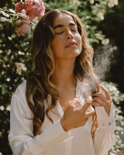 Foto de mujer poniéndose perfume para su cita de San Valentín
