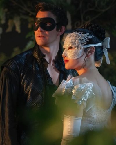 Pareja con máscaras en escena romántica de Bridgerton 4, anticipando el estreno de la segunda parte en Netflix