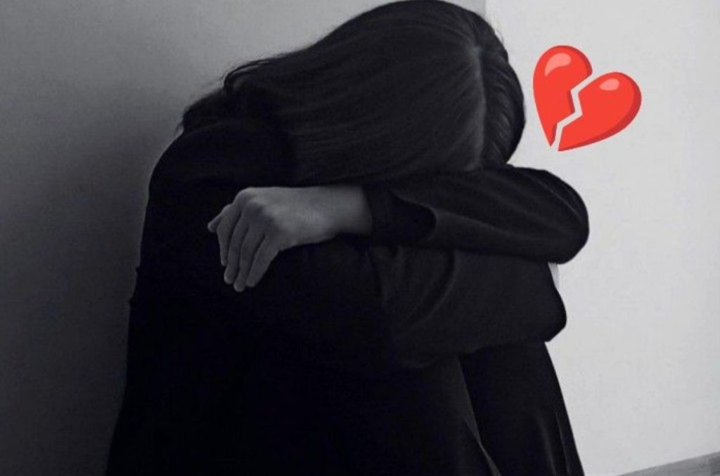 Foto en blanco y negro de una mujer recostada sobre sus piernas con un emoji de corazón rojo, refleja las señales de que tu casi algo te hizo gosthing